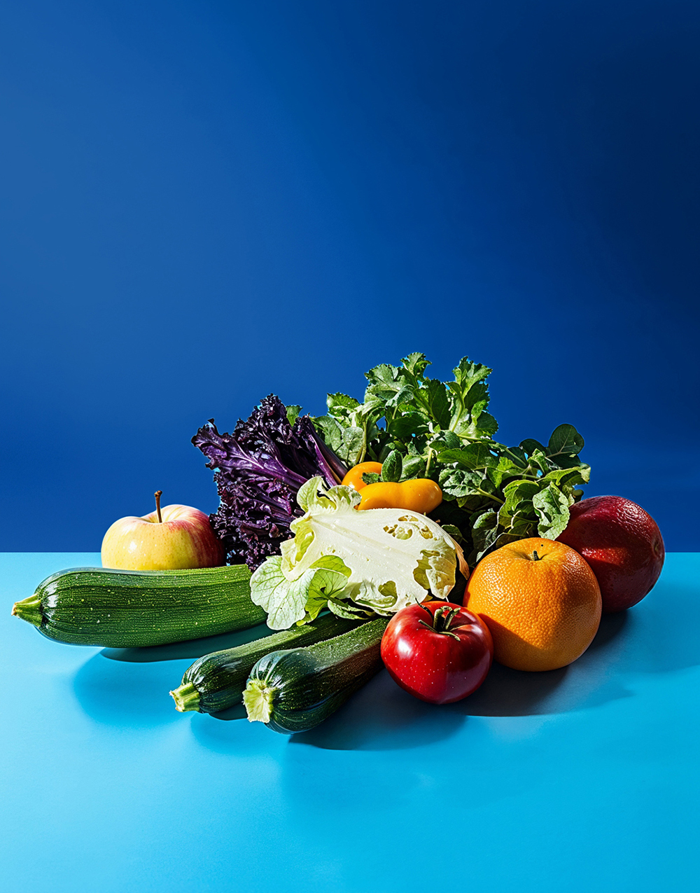 Schmuckbild Obst und Gemüse vor blauem Hintergrund